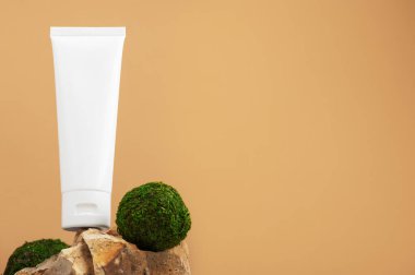 Plastik markasız tüp taşların üzerinde duruyor. Krema için flakon, tuvalet malzemesi. Profesyonel kozmetik ürünleri için konteynır. Çevre dostu kozmetik ürünler konsepti. Mockup, sağ taraftaki boşluğu kopyala.