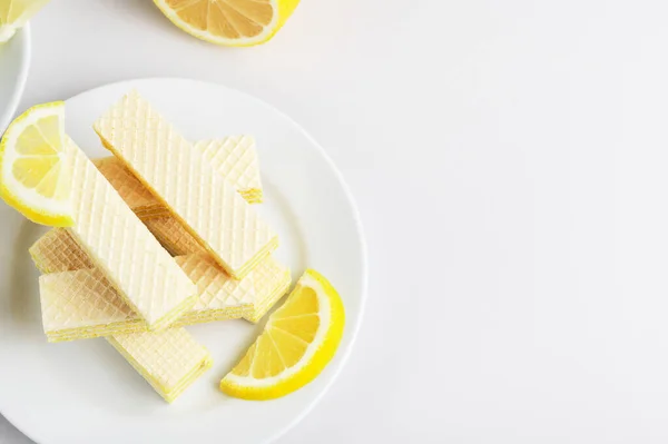 Vista dall'alto del dolce e gustoso dessert. Cialde con ripieno di latte e limone. Cibo gustoso. Fette di limone. Piatti di wafer l'uno sull'altro. Pausa tè. Ricevuto. Isolato su bianco. Concetto di Bun-fight — Foto Stock