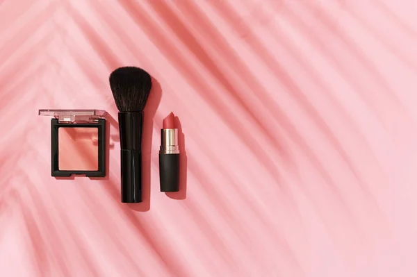 ブラシ メイクブラシ ヤシの葉の上からの影とピンクの背景に口紅 夏の化粧コンセプト 女性の美容製品 アクセサリー コピースペース 平置き — ストック写真