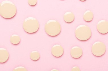 Pembe desenli arka plan görünümlü makyaj malzemesi. Düz kaplama için sıvı sıvıyla kaplanmış numune. Bej krem. Mükemmel yüz düzeltme için kozmetik kapatıcı