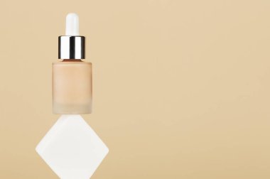 Beyaz kare süngerin üzerinde sıvı bej rengi krema dengesi olan bir şişe. Mükemmel cilt için profesyonel makyaj ürünü. Kadın aksesuarları, temel güzellik ürünleri, astar, kapatıcı. Boşluğu kopyala.