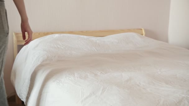 Kvinna viker tillbaka vit varm filt förbereder sängen i rummet — Stockvideo