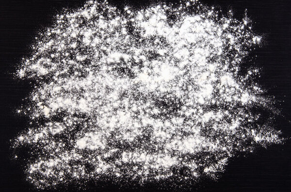 flour sprinkled on a dark table