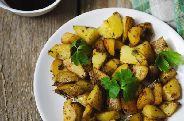 Patate al forno con salsa su un piatto bianco — Foto Stock