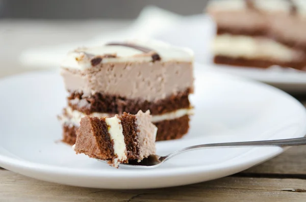 Pedazo de pastel de chocolate en un plato blanco — Foto de Stock