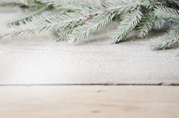 ahşap arka plan üzerinde kar ile yeşil Noel ağacı dalı