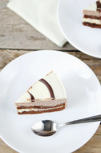 Pedazo de pastel de chocolate en un plato blanco — Foto de Stock