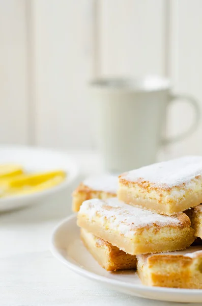 Lemon bars on a white plate with slices — Stock Photo, Image