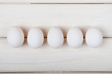 Beyaz ahşap masa üzerinde üst üste beş yumurta