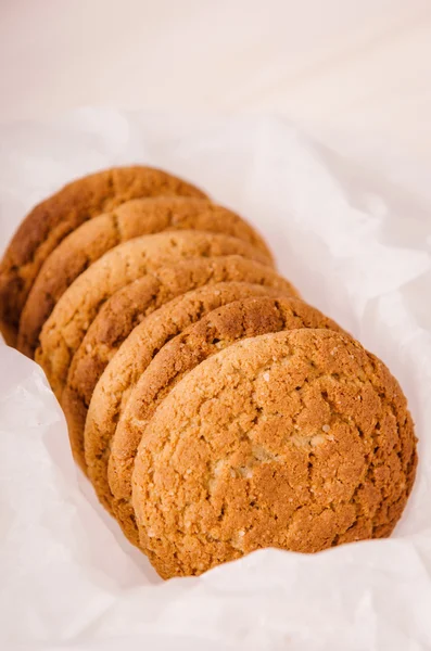 Pila de galletas de avena en caja blanca con papel de panadería — Foto de Stock