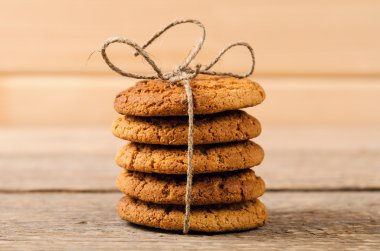 bir bardak süt ile ahşap masa üzerinde rustik yulaf ezmeli kurabiye