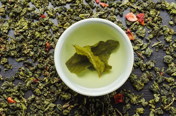 Миски з зеленим довгим чаєм і полуницею — стокове фото