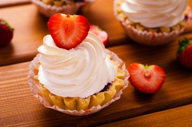 cake with white cream and fresh strawberries on table