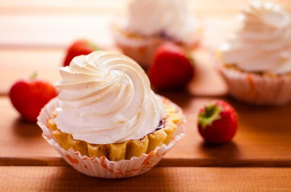 Pastel con crema blanca y fresas frescas en la mesa — Foto de Stock