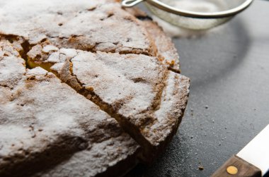 siyah kuş üzümü ve parça ahşap masa üzerinde kesmek şeker ile pasta