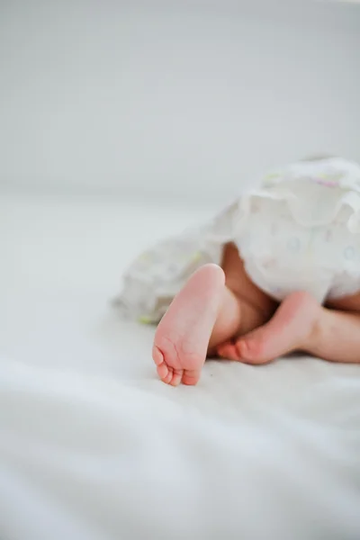 Schattige baby kruipen op het bed. — Stockfoto