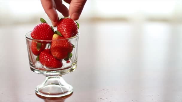 Hand lässt eine Erdbeere fallen — Stockvideo