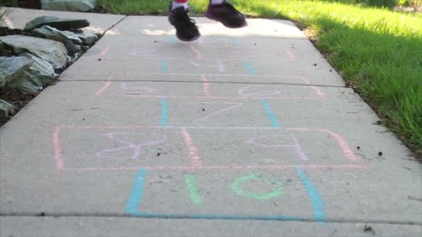 Niño jugando hopscotch — Vídeo de stock