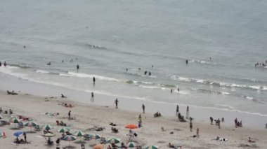İnsanlar sahilde eğleniyor.