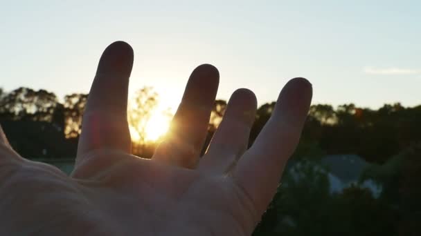 Parmaklarının arasından geçen güneş — Stok video