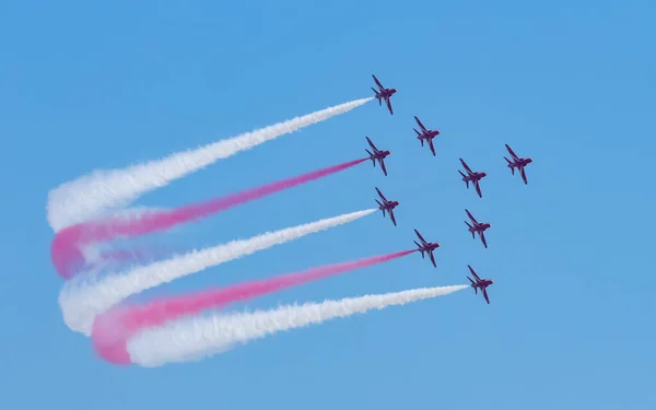 Mavi gökyüzünde, renkli dumanla uçan bir jet uçağı. Çin 'in Guangdong Eyaleti, Zhuhai' deki hava gösterisinde uzay sergisi..