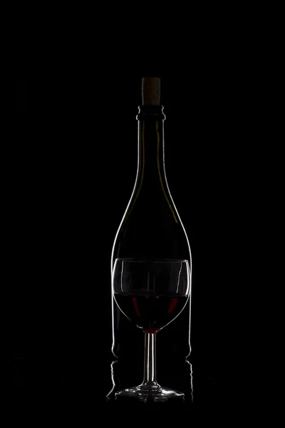 Botella de vino y una copa de vino sobre fondo negro, mínimos —  Fotos de Stock