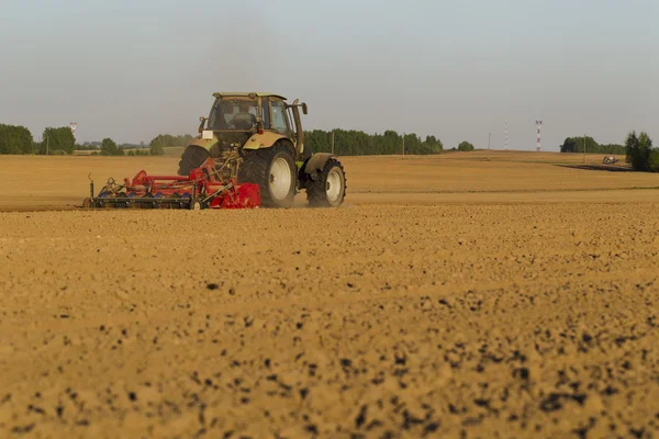 Traktor di lapangan pada operasi pertanian — Stok Foto