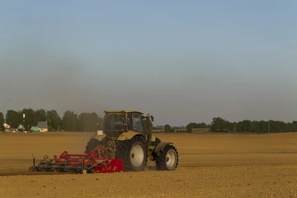 El tractor en el campo sobre las operaciones agrícolas —  Fotos de Stock