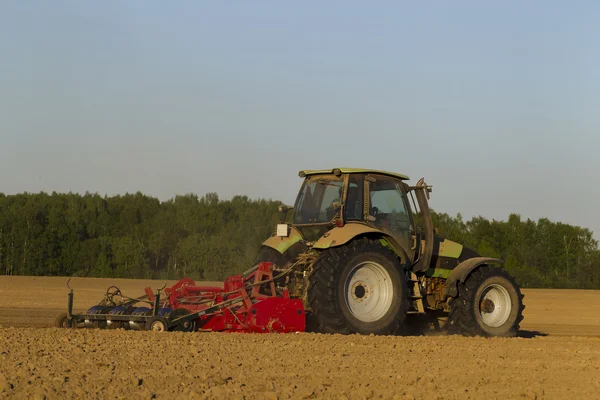 Traktor di lapangan pada operasi pertanian — Stok Foto