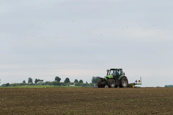 Traktor di lapangan pada operasi pertanian — Stok Foto