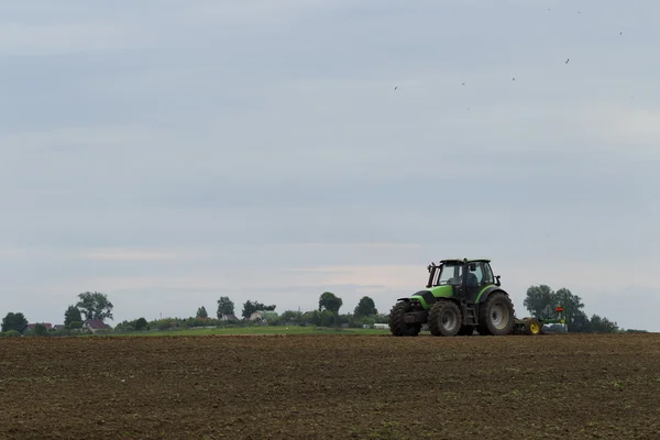 Traktor di lapangan pada operasi pertanian — Stok Foto