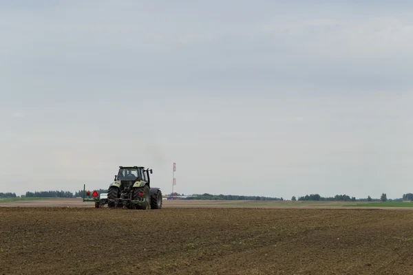 Трактор в поле на сельскохозяйственных работах — стоковое фото