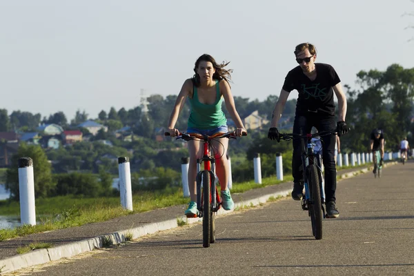 Bir bisiklet şehir kız ve genç adam binmek — Stok fotoğraf