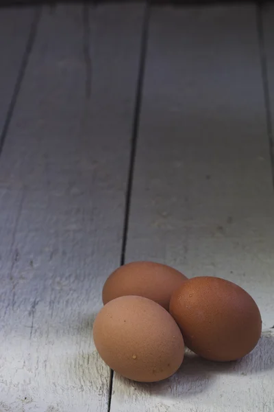 Ovos em uma bandeja de papelão contra tábuas brancas . — Fotografia de Stock