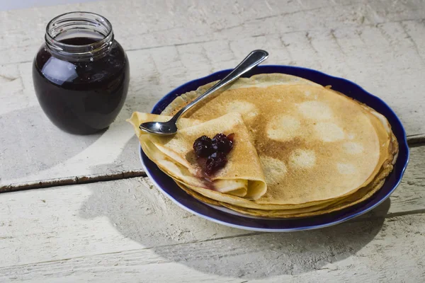 Pancakes with jam on a wooden background. — Stock Photo, Image