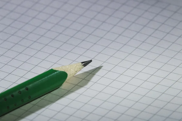 Zelená tužka na notebook — Stock fotografie