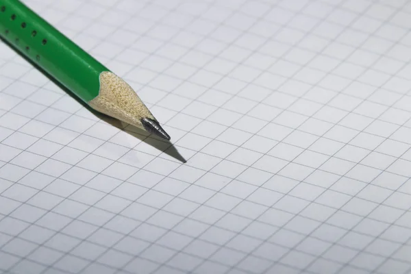 Zelená tužka na notebook — Stock fotografie