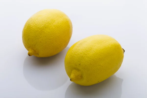 Dwie żółte cytryny na białym tle — Zdjęcie stockowe