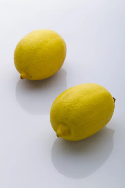 Два желтых лимона на белом фоне — стоковое фото