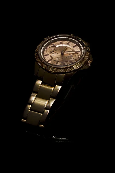 Gold watch on a plastic background — Stock Photo, Image