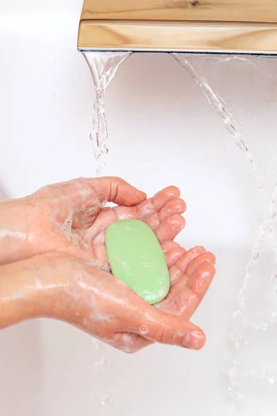 A gyermek szappannal mossa a kezét egy csapvíz alatt, tiszta vízzel. Higiéniai koncepció. Betegségmegelőzés, egészségügyi ellátás. — Stock Fotó