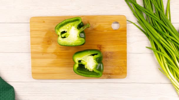 Proces krájení zelené papriky na bílém dřevěném stole.Stop animace pohybu — Stock video