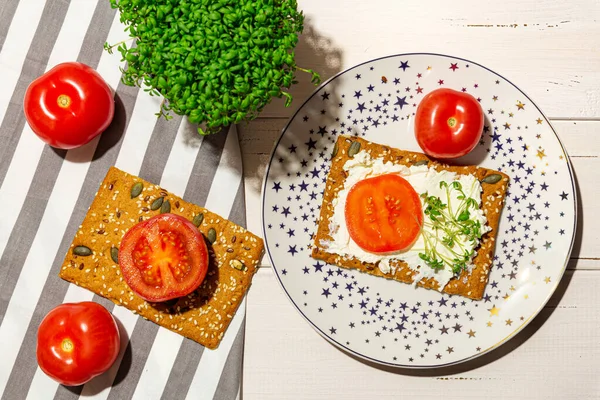 Sandwich dengan keju lembut, tomat, microgreens di piring. Letak rata. — Stok Foto