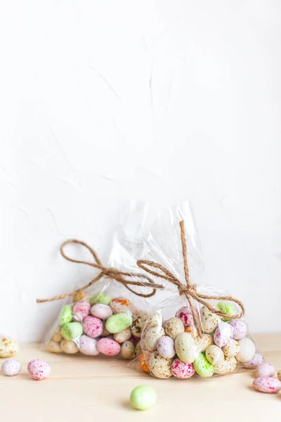Chocolate Easter eggs, candy in glaze in a transparent bag on a light background