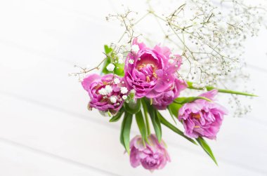 Romantik, narin pembe laleler ve beyaz arka planda çingene çiçekleri..