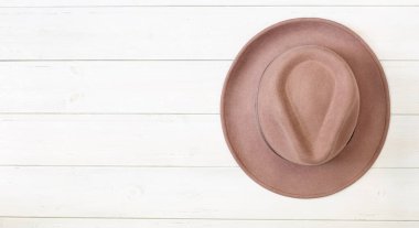 Beyaz tahtaların duvarında bej ya da pudra renginden yapılmış bir fötr şapka vardı..