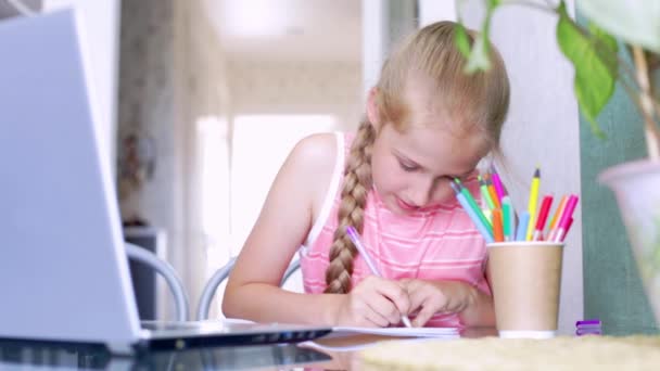 Caucásico chica escribe en un cuaderno, hablando emocionalmente a profesor en línea — Vídeos de Stock