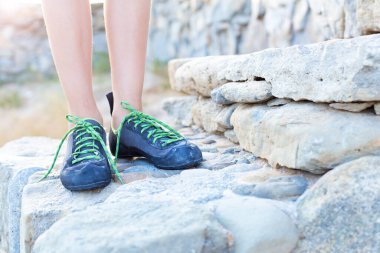 Tırmanma ayakkabıları içinde bacaklar, taş basamaklarda durmak, yakın çekim..
