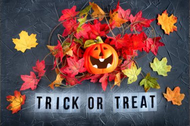 Şeker mi şaka mı, akçaağaç yapraklı gülen balkabağı siyah desenli arka planda