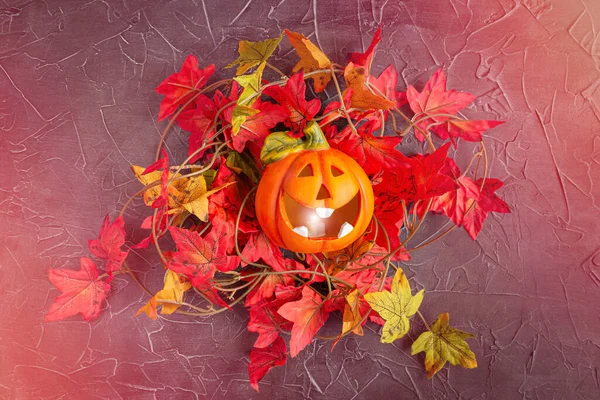 Laughing pumpkin Jack-o-lantern in maple leaves on glowing neon background. — Stock Photo, Image